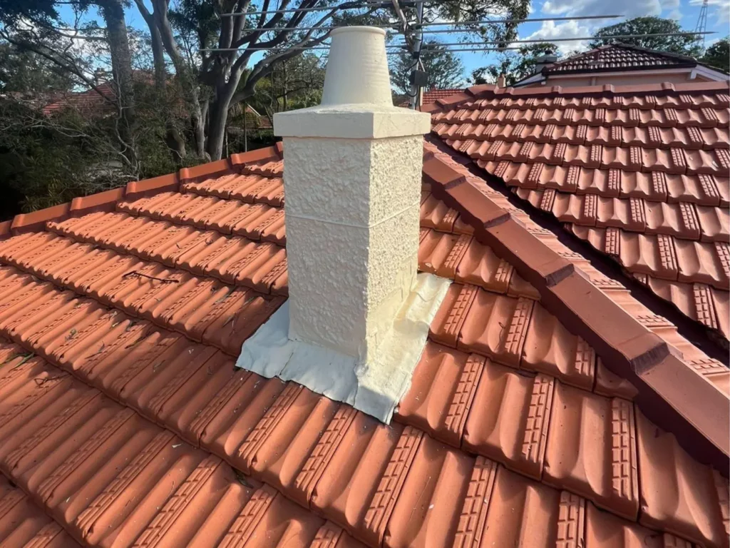 Terracotta tile roof with a rendered chimney